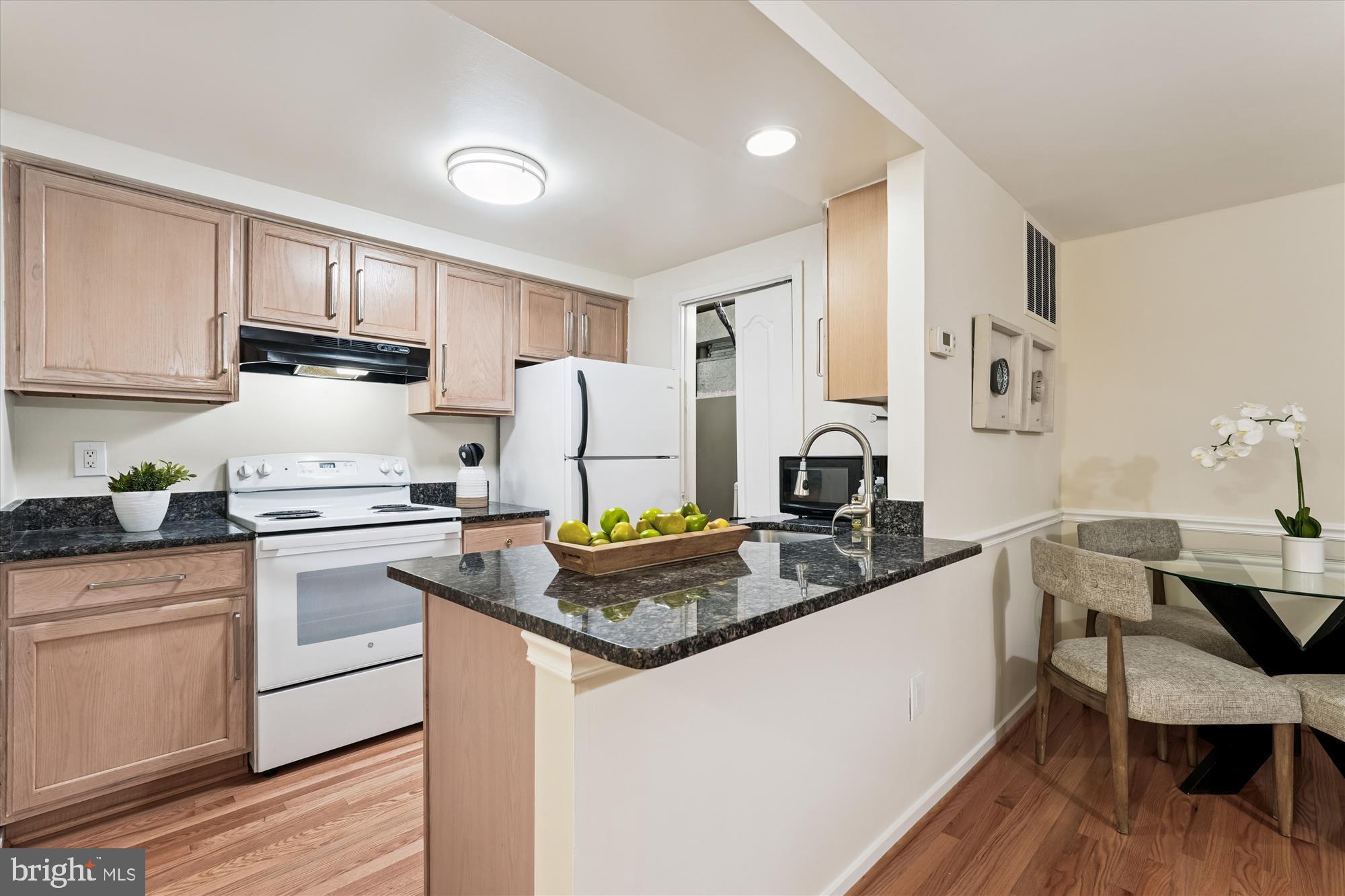9731 Hellingly Place, Unit 37 Montgomery Village, MD 20886 - Photo 7 of 20 a kitchen with a stove a refrigerator and a dining table