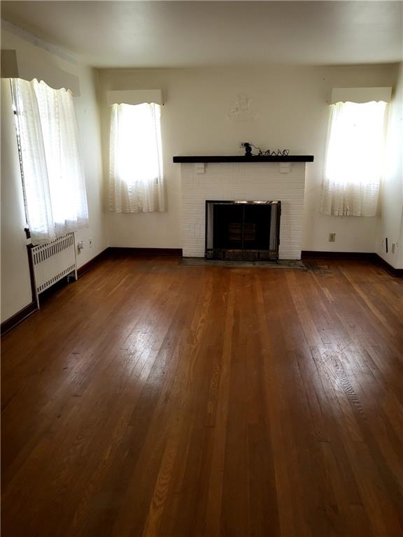 1003 Maple Avenue Turtle Creek, PA 15145 - Photo 3 of 24 an empty room with wooden floor fireplace and windows