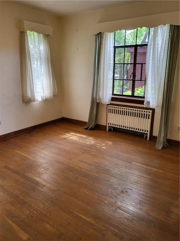 1003 Maple Avenue Turtle Creek, PA 15145 - Photo 7 of 24 an empty room with wooden floor and windows