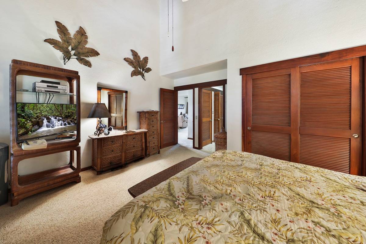 2721 Poipu Road, Unit 133 Koloa, HI 96756 - Photo 12 of 18 a bedroom with a large bed and a chandelier