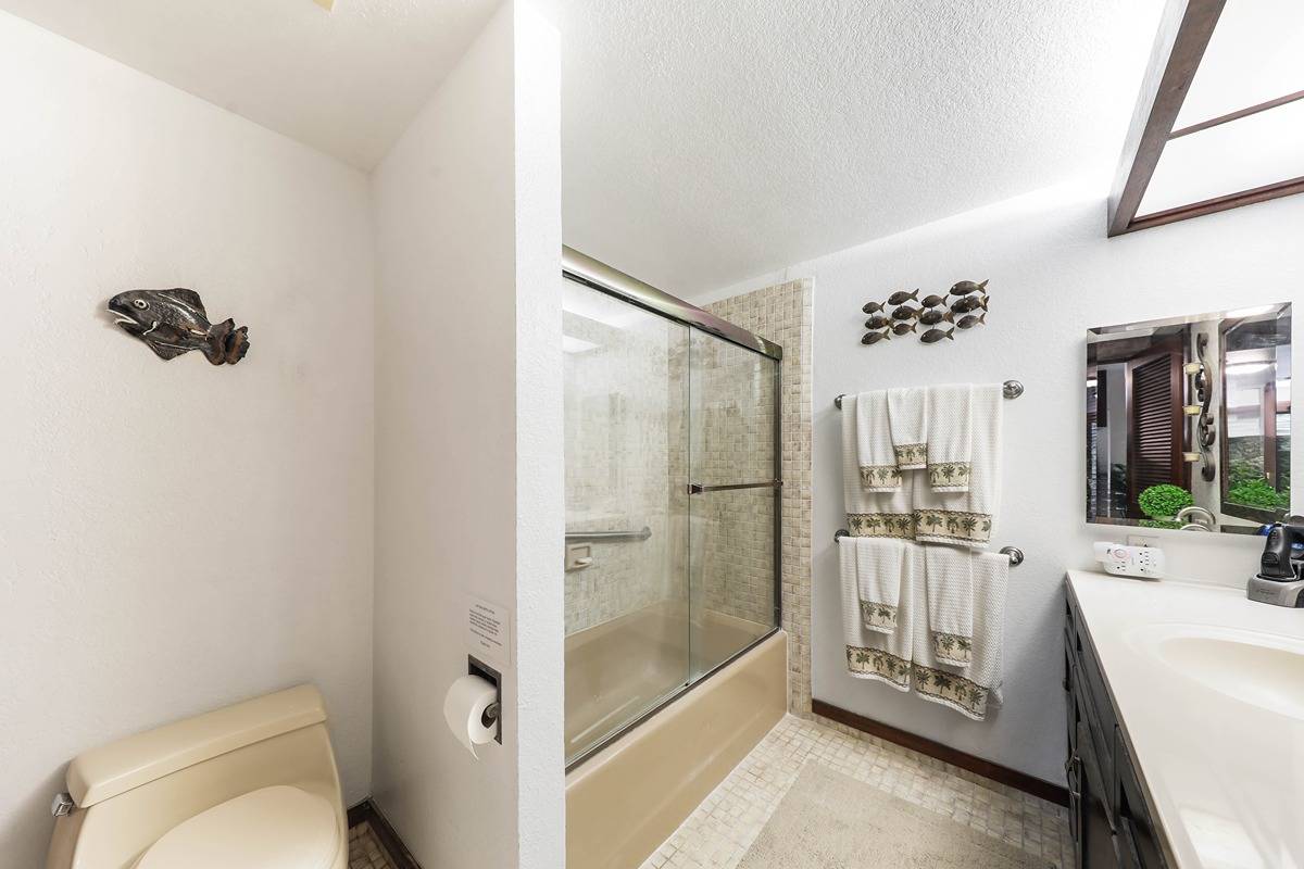 2721 Poipu Road, Unit 133 Koloa, HI 96756 - Photo 9 of 18 a bathroom with a granite countertop sink mirror vanity and toilet
