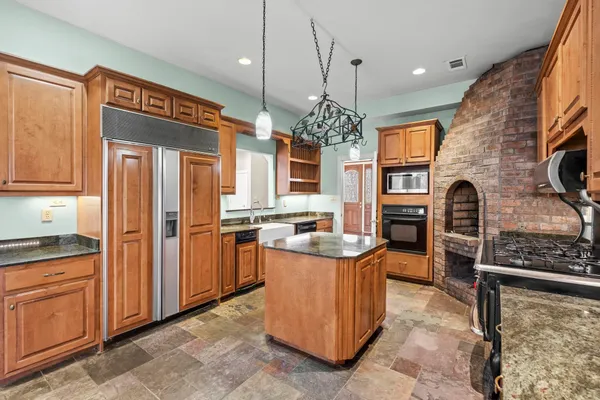 a large kitchen with stainless steel appliances granite countertop a stove and a refrigerator