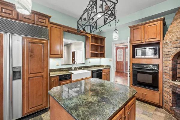 a kitchen with stainless steel appliances granite countertop a stove top oven microwave and refrigerator