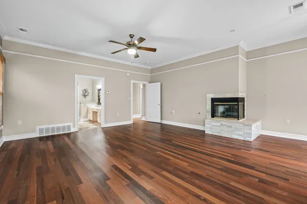 a view of empty room with wooden floor and ceiling fan