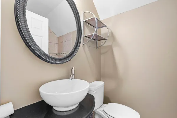 a bathroom with a toilet a sink and a mirror