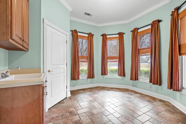 a view of an empty room with chandelier fan and fire place