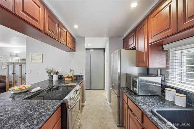 a kitchen with granite countertop a sink and a stove