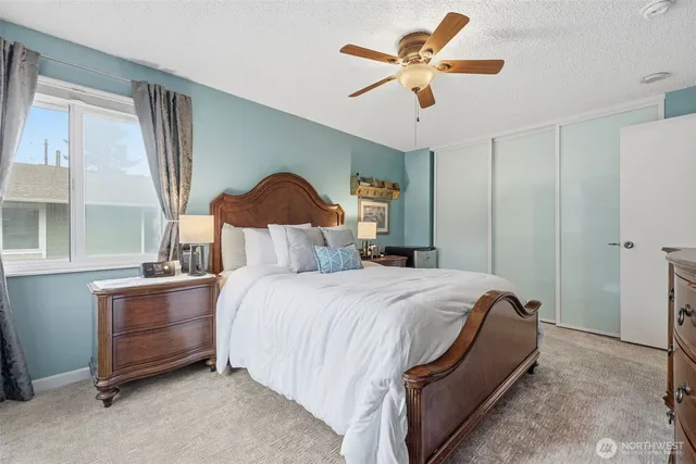 a bedroom with a bed chandelier and a window