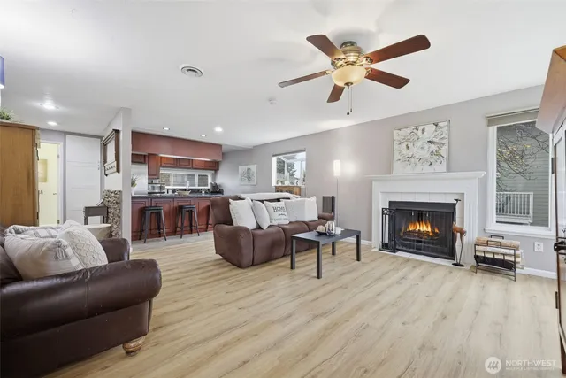 a living room with furniture a fireplace and kitchen view