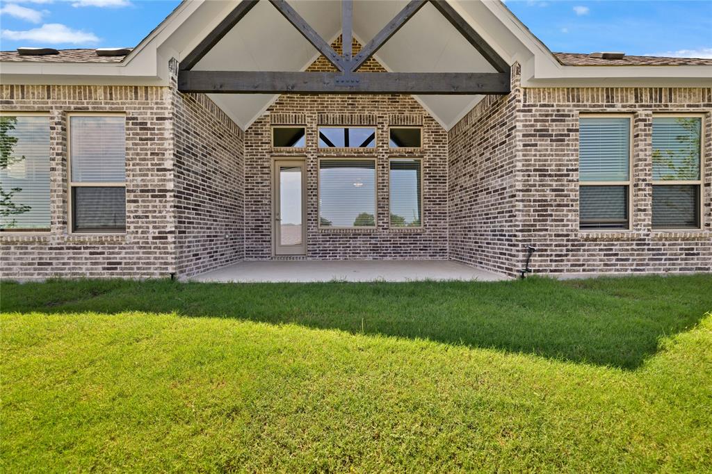 2307 Sam Street Mansfield, TX 76063 - Photo 21 of 23 Doorway to property featuring brick siding, a patio, and a lawn