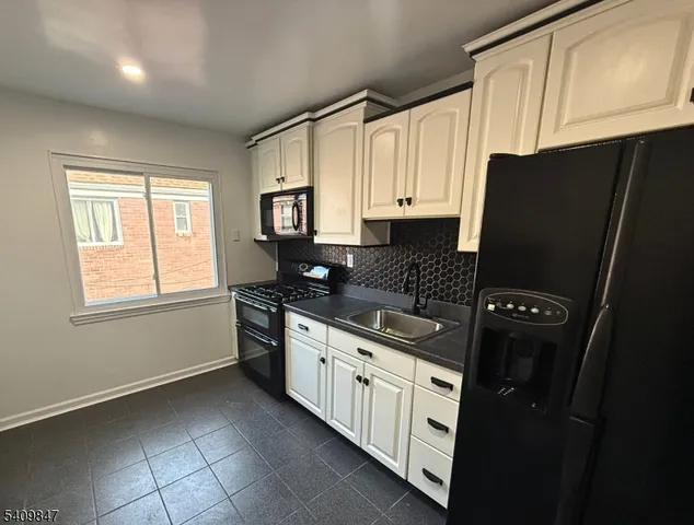 a kitchen with stainless steel appliances a refrigerator sink and cabinets
