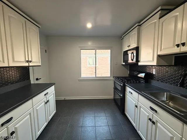 a kitchen with a sink stove and cabinets