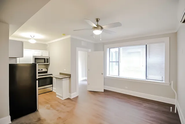 a view of a kitchen with refrigerator and windows