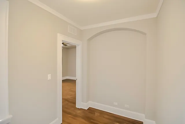 a view of an empty room with wooden floor and closet