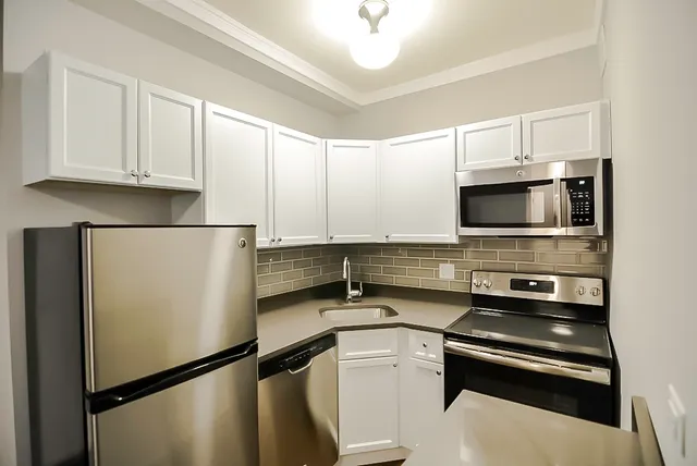 a kitchen with stainless steel appliances a refrigerator sink and microwave