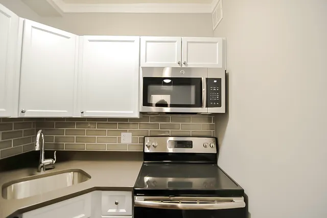 a kitchen with granite countertop a stove and a sink