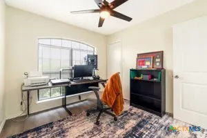 a view of a workspace with furniture and a window