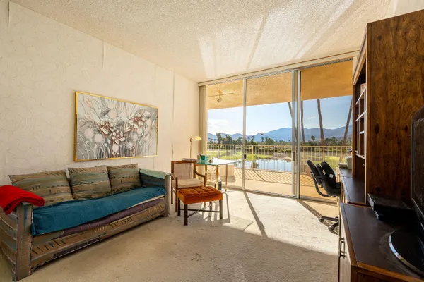 a living room with furniture and a floor to ceiling window