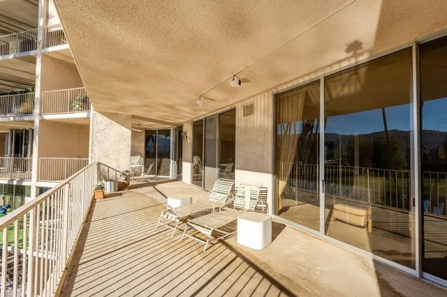 a view of a patio with couches dining table and chairs with wooden floor