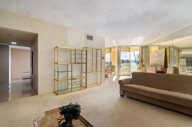 a living room with furniture and a floor to ceiling window