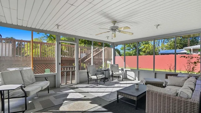 a living room with patio furniture and a floor to ceiling window