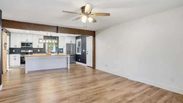 a large kitchen with granite countertop a large counter top stainless steel appliances and cabinets