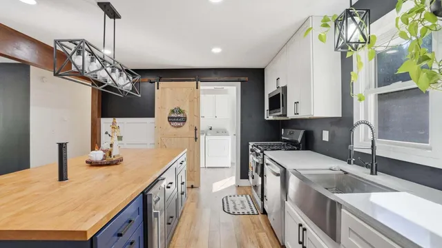a kitchen with stainless steel appliances granite countertop a sink a stove and a wooden floors