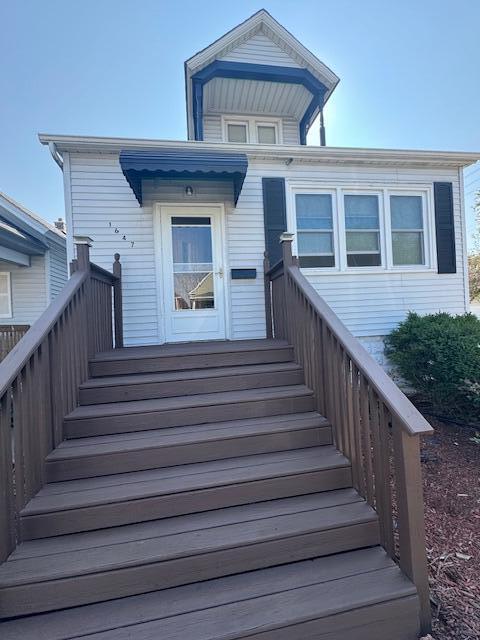 1647 Myrtle Avenue, Unit 1 Whiting, IN 46394 - Photo 1 of 20 a view of a house with wooden stairs and a table