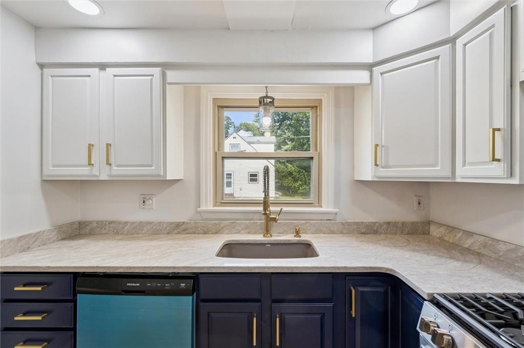1167 Lapish Road Pittsburgh, PA 15212 - Photo 12 of 45 a kitchen with granite countertop a sink white cabinets and a window