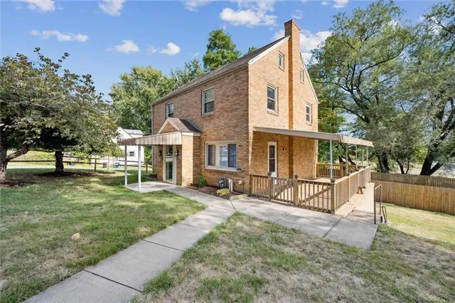 a view of a house with backyard and sitting area