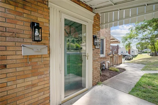 a view of a brick house with a glass door and a outdoor space