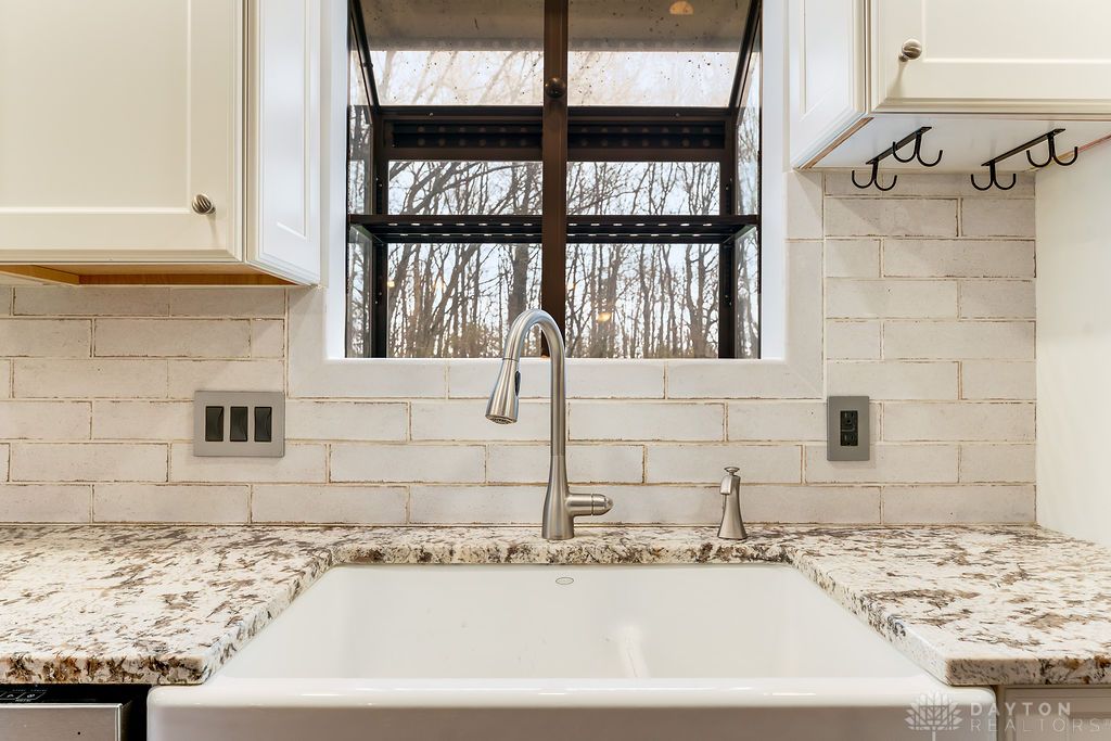 7400 Cook-Jones Road Waynesville, OH 45068 - Photo 40 of 72 This bright kitchen features a large window, a classic farmhouse sink, and elegant granite countertops.