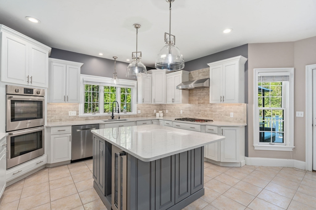220 Newtown Road Acton, MA 01720 - Photo 4 of 39 a kitchen with kitchen island granite countertop a sink stove and refrigerator