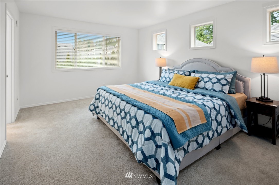4421 220th Street Southeast Bothell, WA 98021 - Photo 24 of 39 a large bed sitting in a bedroom next to a lamp