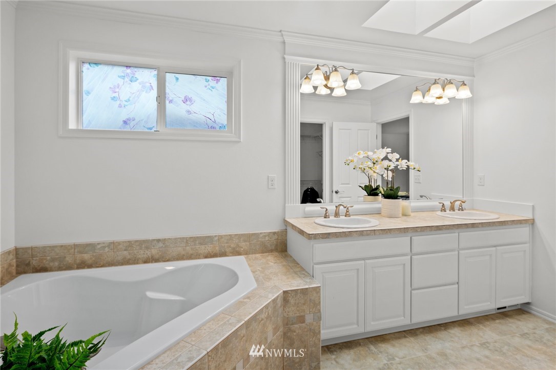4421 220th Street Southeast Bothell, WA 98021 - Photo 26 of 39 a bathroom with a granite countertop sink a large mirror and a bathtub