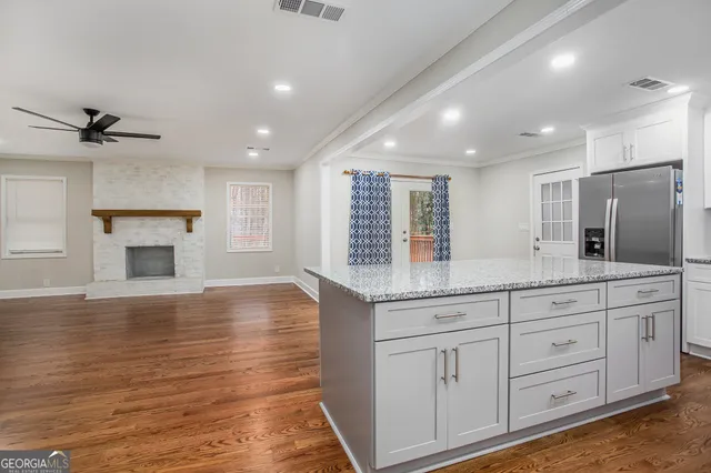 a spacious bathroom with a granite countertop sink a mirror and shower