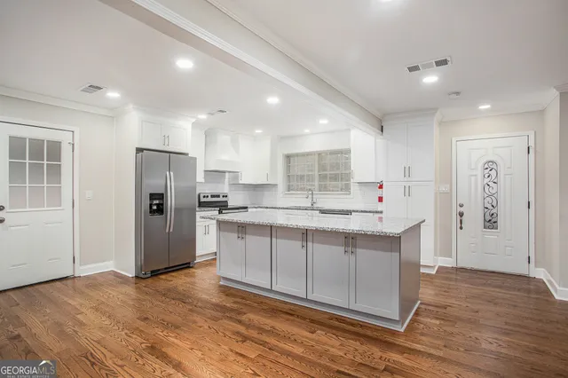 a kitchen with stainless steel appliances granite countertop a refrigerator and a sink