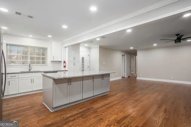 a large kitchen with stainless steel appliances granite countertop a large center island and a sink