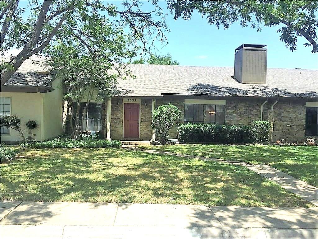 a backyard of a house with potted plants and large tree