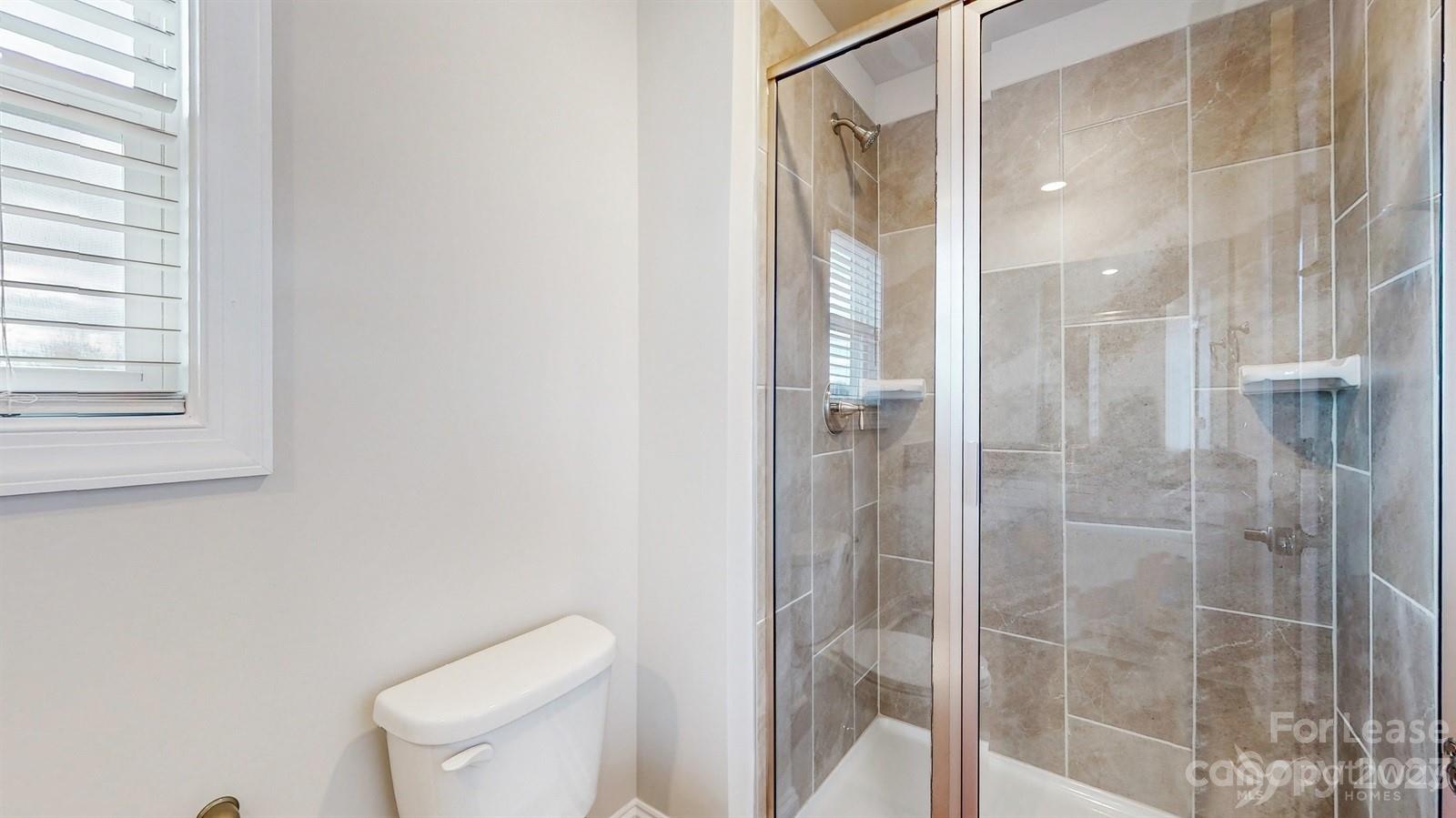 163 Brixham Loop Troutman, NC 28166 - Photo 18 of 34 a bathroom with a shower and toilet