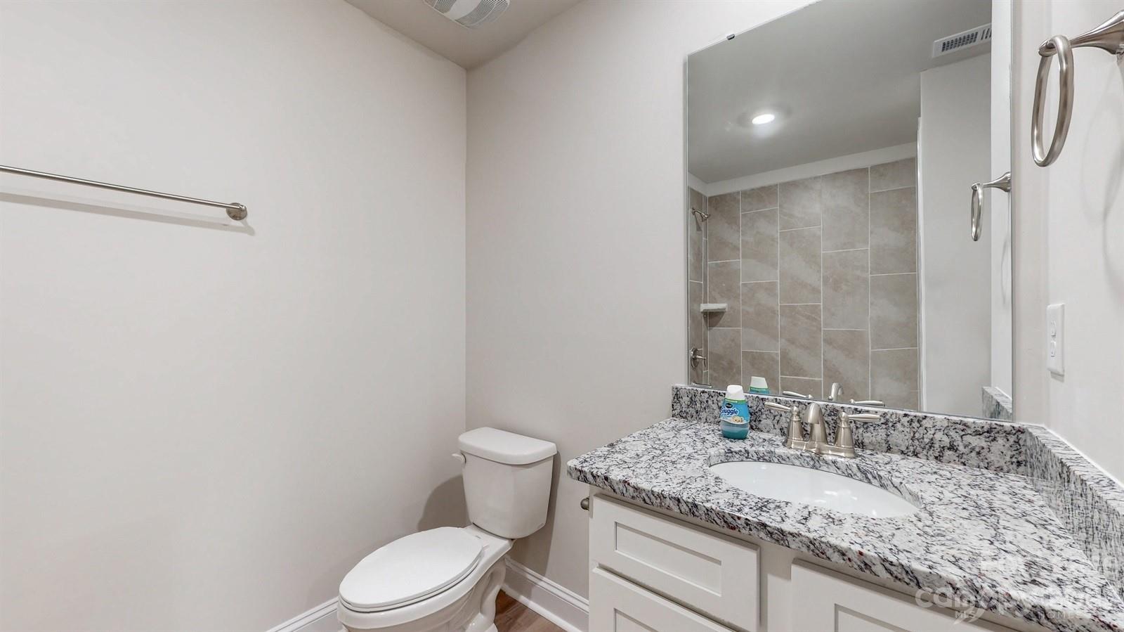 163 Brixham Loop Troutman, NC 28166 - Photo 24 of 34 a bathroom with a granite countertop sink mirror vanity and toilet