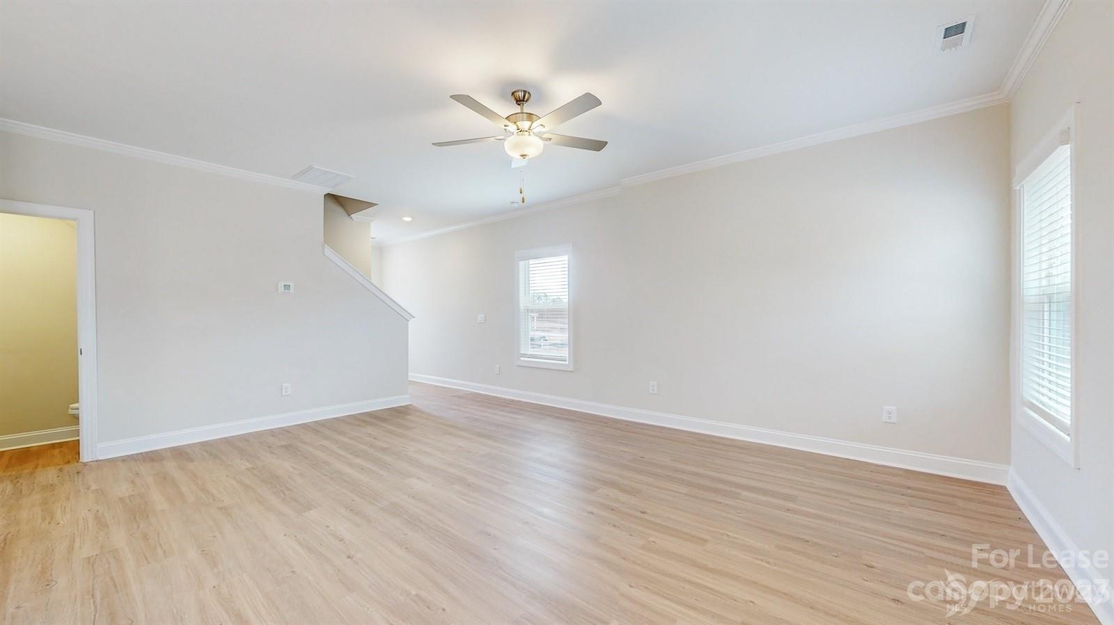 163 Brixham Loop Troutman, NC 28166 - Photo 3 of 34 a view of an empty room with wooden floor and a window