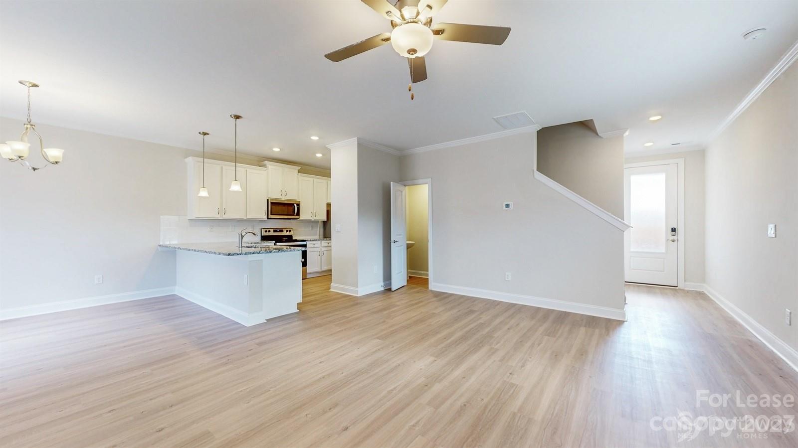 163 Brixham Loop Troutman, NC 28166 - Photo 4 of 34 a view of kitchen with refrigerator microwave and stove