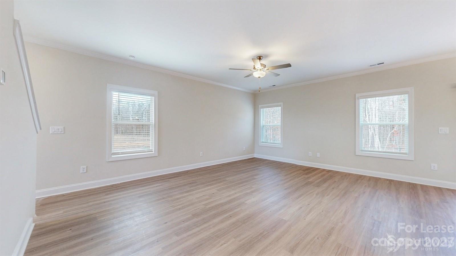 163 Brixham Loop Troutman, NC 28166 - Photo 5 of 34 a view of an empty room with a window and wooden floor