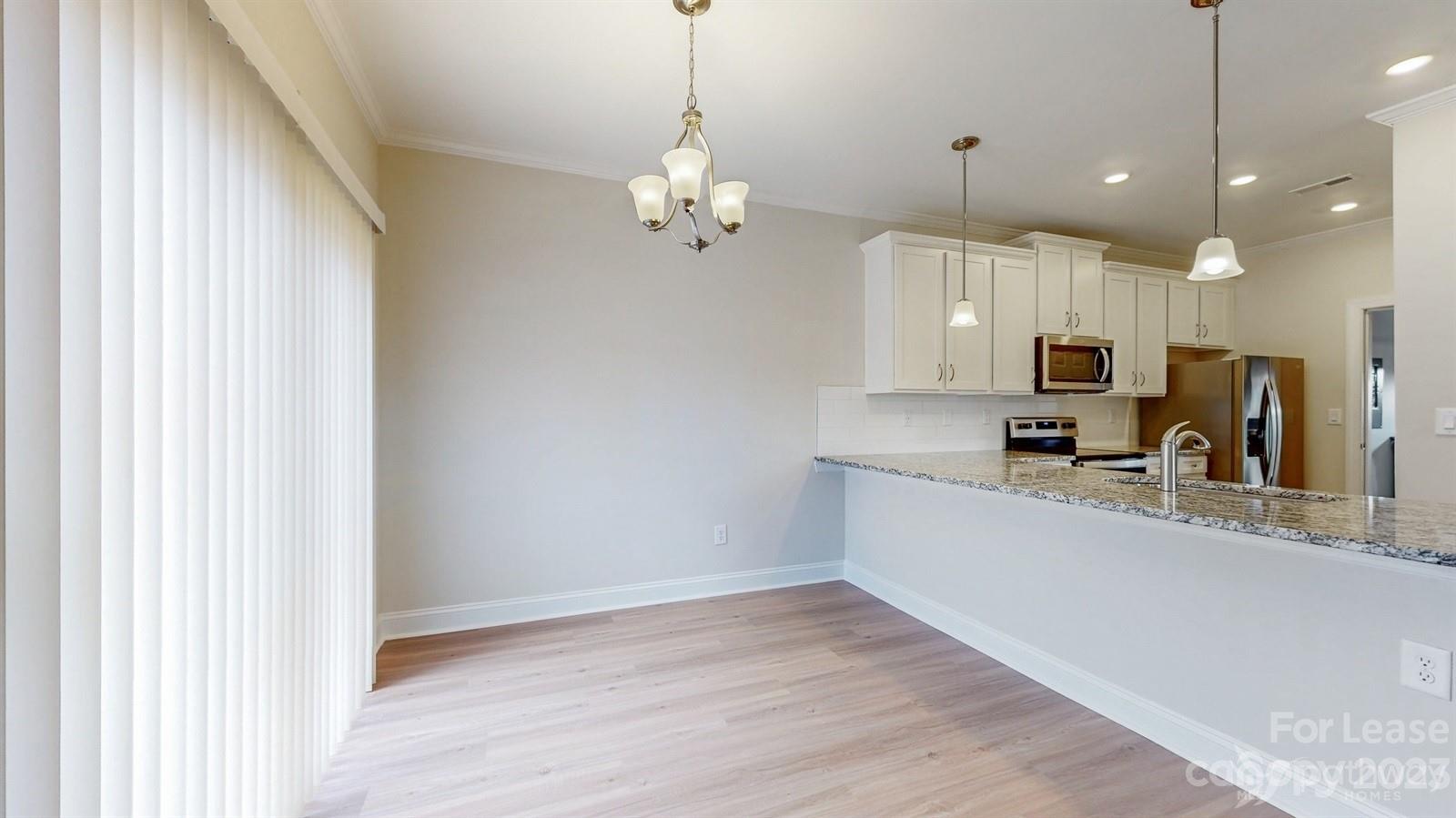 163 Brixham Loop Troutman, NC 28166 - Photo 6 of 34 a large kitchen with granite countertop a large counter space a sink and appliances