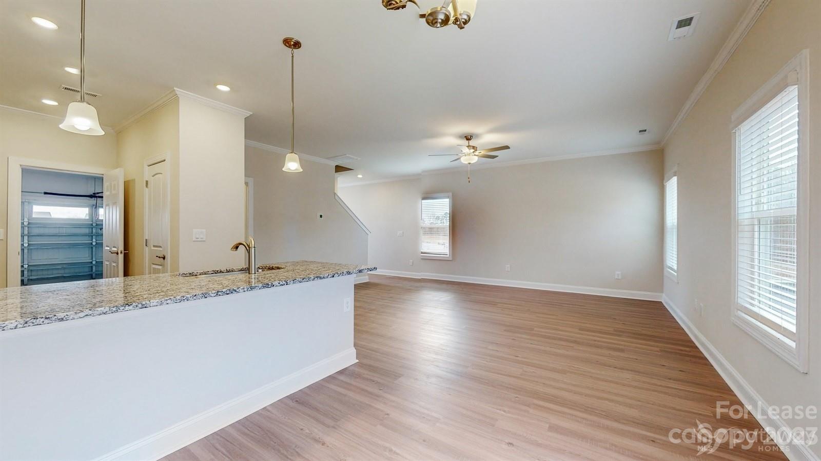 163 Brixham Loop Troutman, NC 28166 - Photo 7 of 34 an empty room with wooden floor and windows