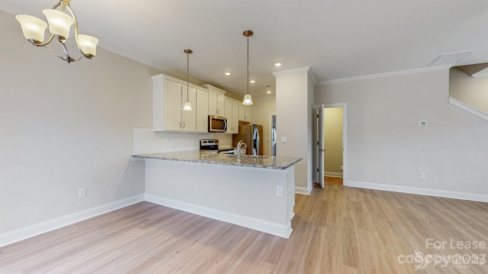 163 Brixham Loop Troutman, NC 28166 - Photo 8 of 34 a view of a kitchen with wooden floor