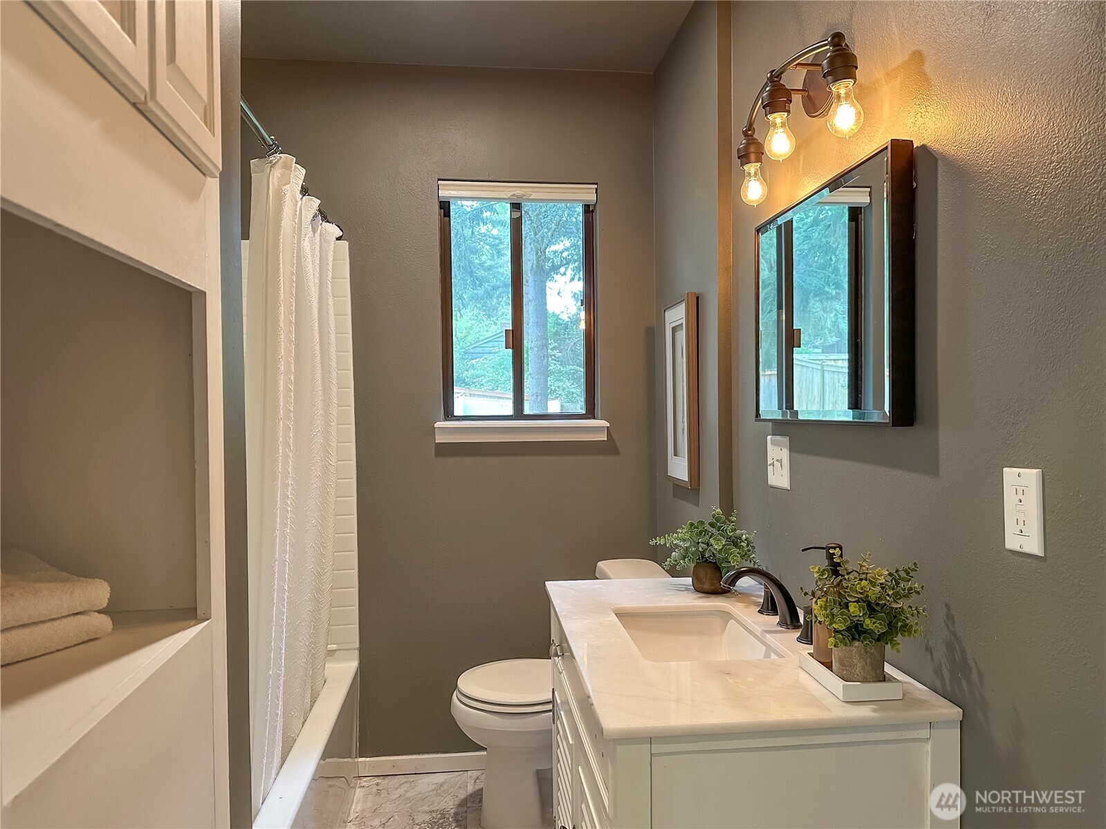 912 Northeast 115th Street Seattle, WA 98125 - Photo 10 of 21 a bathroom with a sink toilet and mirror