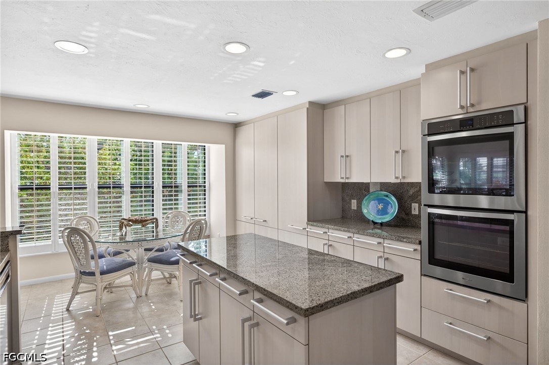 1057 Sand Castle Road Sanibel, FL 33957 - Photo 9 of 50 a kitchen with stainless steel appliances granite countertop a stove a microwave a sink and cabinets