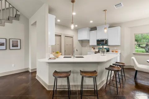 a kitchen with kitchen island a dining table and chairs